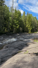 Drone operator documents equipment and river scenery in Bø