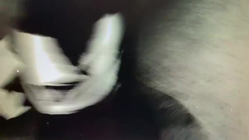 This is a grainy, black and white video showing abstract figures and shapes in soft focus. It appears to be a performance or a stylized representation of movement. The first frame shows a dark silhouette of a head and shoulders with a bright, hazy glow around it. The second frame shows a full body silhouette of a person with arms outstretched, illuminated by a bright circle of light from behind. The third frame is a close-up of a blurry figure with a mask or face covering. The fourth frame shows a dark, abstract shape with bright circles of light on either side. The fifth frame shows a silhouette of a person with their head down, appearing to be in distress or deep thought. The final frame shows a silhouette of a person in a suit, with their arm raised to their head. The video is filled with visual artifacts such as specks and streaks, contributing to its vintage or experimental aesthetic.