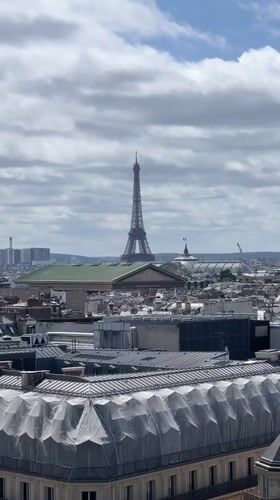 Tourists capture Paris skyline views near opera house