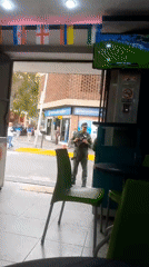 Street-level Caracas activity near Av. Bolívar, armed guard at pharmacy