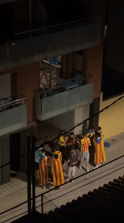Catalan flag-draped group out on Canet de Mar streets at night