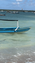 Morning beach scenes with boats and kites captured in Denpasar