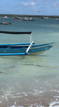 Morning beach scenes with boats and kites captured in Denpasar
