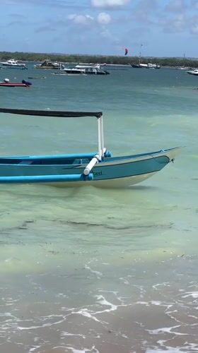 Morning beach scenes with boats and kites captured in Denpasar