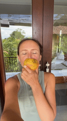 Woman displays red fruit near balcony in Ubud, Indonesia