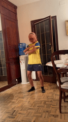 Pink-haired person dances in soccer jersey in Barcelona room