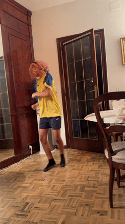 Pink-haired person dances in soccer jersey in Barcelona room