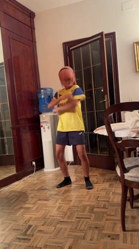 Pink-haired person dances in soccer jersey in Barcelona room