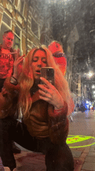Woman takes street selfie amid projected lights in Amsterdam