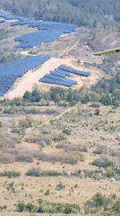 Small aircraft flies over solar farm in Bulgarian countryside