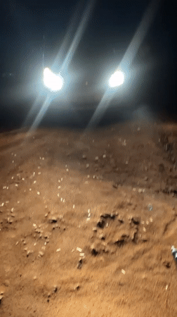 Nighttime vehicle activity captured on dirt road in Bukuru