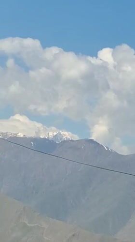 Snow-covered mountains filmed from vehicle in Tajikistan