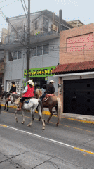Horseback riders in cowboy hats ride through Altotonga streets