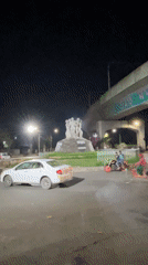 Illuminated people sculpture documented at Dhaka roundabout after dark