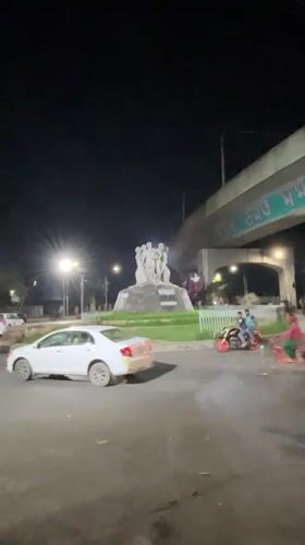Illuminated people sculpture documented at Dhaka roundabout after dark
