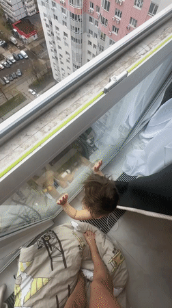 Child observed at high-rise window in Russian residential area