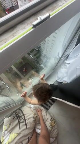 Child observed at high-rise window in Russian residential area