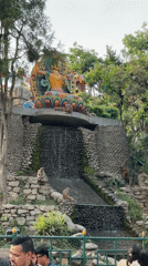 Monkeys gather around waterfall statue in Kathmandu