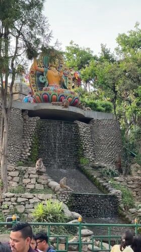 Monkeys gather around waterfall statue in Kathmandu