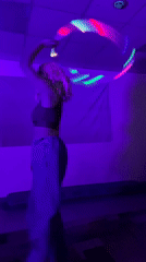 Woman spins LED light toy in violet-lit room, Chaikovsky