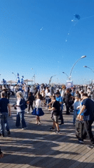 Dancing crowd gathers on Tel Aviv waterfront boardwalk