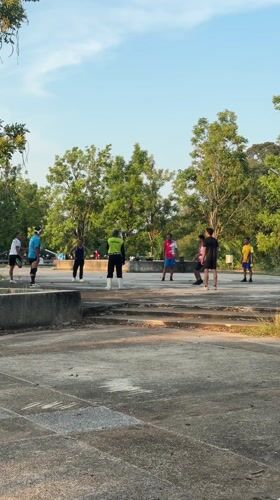 Volleyball game on concrete platform near water in Kathu