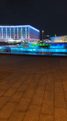 Evening bridge visit captures illuminated fountain, city reflections