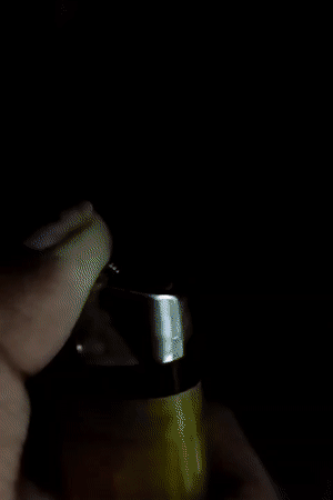 Person lights mosquito coil with lighter in Dhaka evening