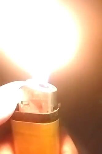 Person lights mosquito coil with lighter in Dhaka evening