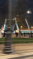 Nighttime drawbridge operation observed with pedestrian activity nearby