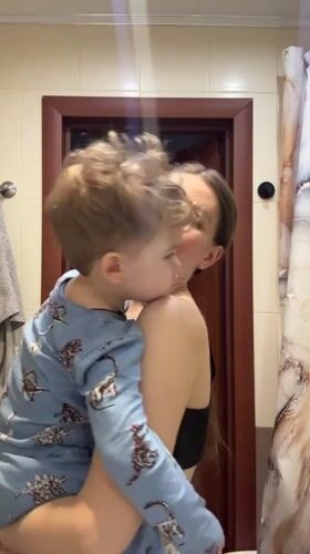 Woman holds child in bathroom during early morning hours