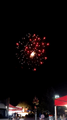 Traditional dance performance at nighttime festival with fireworks