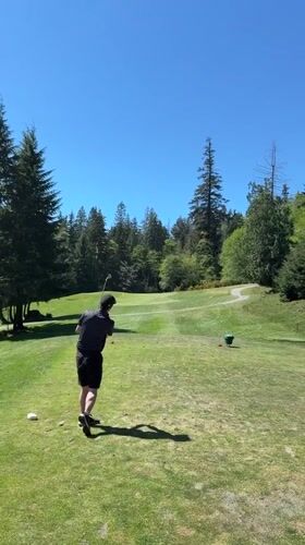 Golfer plays course on Bowen Island during clear evening