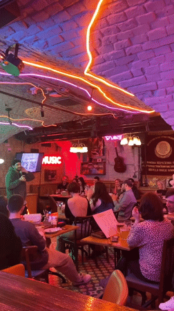 Evening social gathering at neon-lit bar in Saratov