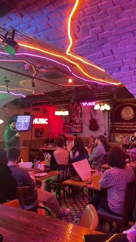 Evening social gathering at neon-lit bar in Saratov