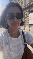 Woman rides scooter through Paris streets wearing headphones