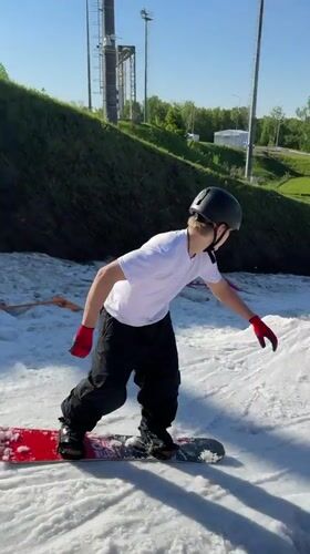 Snowboarders practice tricks on summer snow patches in Krasnoyarsk