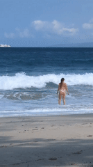 Morning at a Manggis beach, waves, white bikini, ferry on the horizon