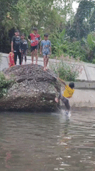 Children jump from rocks into canal in Saweuk