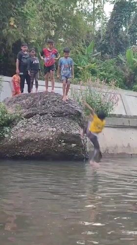 Children jump from rocks into canal in Saweuk