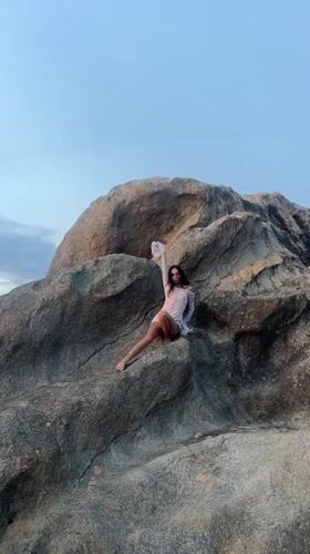 Woman poses on rock formation in Balapitiya, Sri Lanka