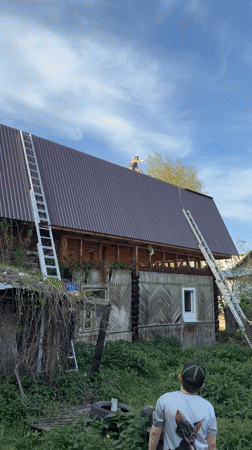 Roofing crew repairs wooden buildings in Perm, Russia