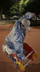 Adult rides playground spring toy at night in Spain