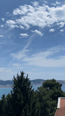 Person enjoys strawberries on balcony overlooking Šušanj, Montenegro