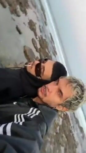 Two men pose for photo near Haifa beach