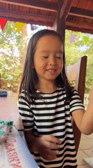 Young girl plays with toys at patio table in Vietnam