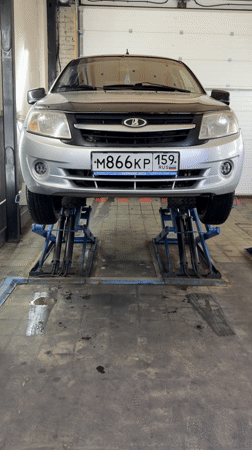 Silver Lada elevated on lifts in Chaikovsky repair shop