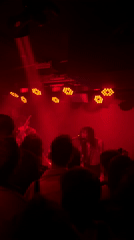 Band performs under red lights in Milan venue