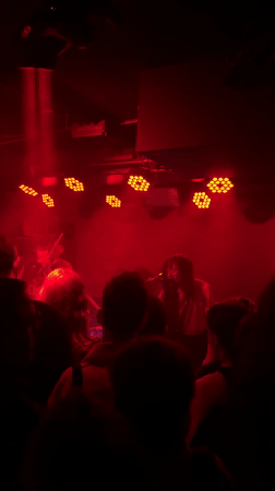 Band performs under red lights in Milan venue