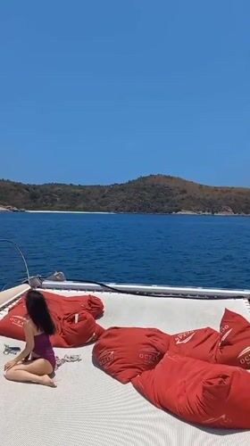 Woman relaxes on catamaran deck in Bang Sare, Thailand